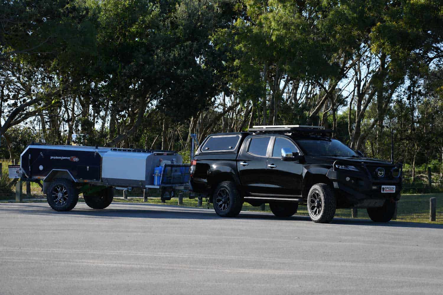 Black Mitsubishi Triton towing a camper trailer